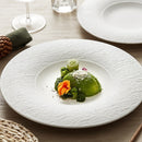 Elegant white ceramic plate with a subtle textured surface, designed for fine dining and gourmet food presentation.