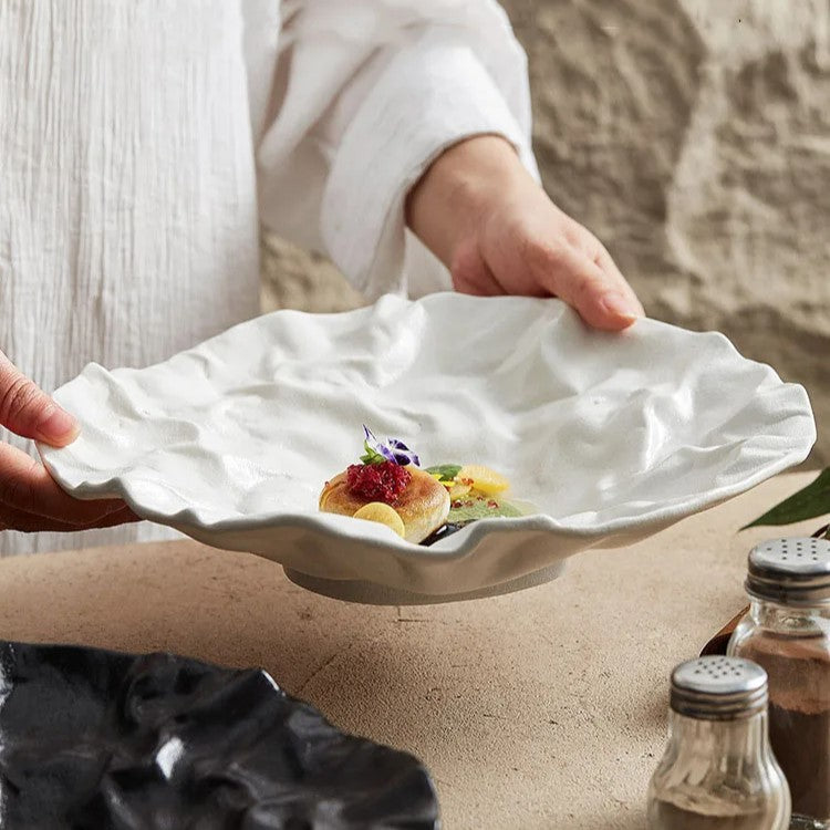 Artistic wave-edged ceramic plate with a textured surface, showcasing a Michelin star-style gourmet dish, ideal for fine dining presentations and luxury table settings