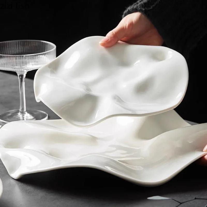 White ceramic plate with a unique wavy and fluid design, ideal for creative food presentations and modern fine dining aesthetics