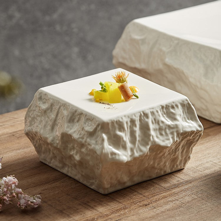 Textured square ceramic plate with a stone-like appearance, designed for artistic food presentation and high-end dining experiences