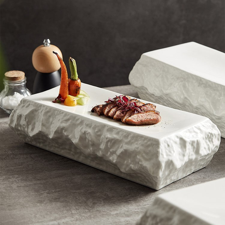 Rectangular ceramic serving plate with a textured stone-like surface, ideal for gourmet food presentation and modern fine dining.