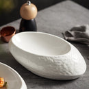 White oval ceramic bowl with a textured exterior, designed for contemporary dining and creative food presentation.