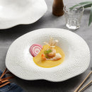 hite ceramic plate with an irregular wavy rim and textured surface, ideal for sophisticated food presentation in fine dining.